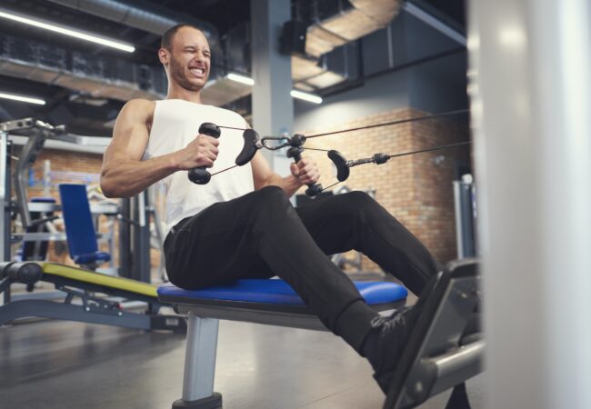 Male Athlete Working On Rowing Machine